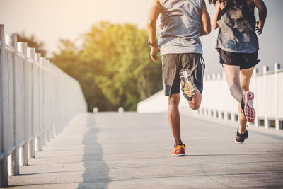 Low section of women running on footpath