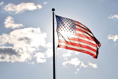 Low angle view of american flag against blue sky