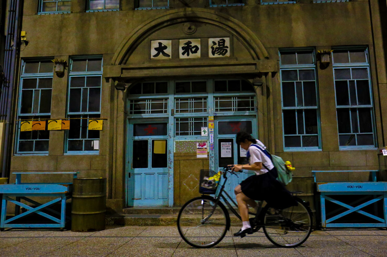 SIDE VIEW OF MAN RIDING BICYCLE ON ROAD