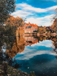 Scenic view of lake by buildings against sky