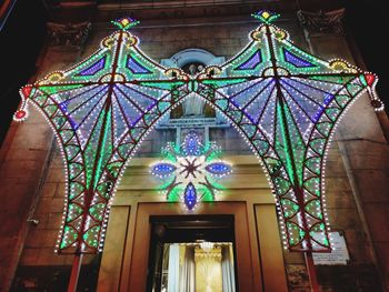 Low angle view of illuminated lanterns hanging on building