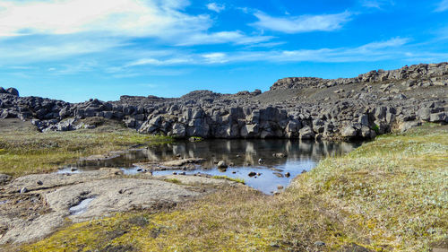 Panoramic view of lake and rocks against sky