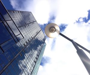 Low angle view of modern building against cloudy sky