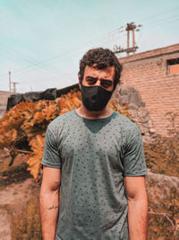 Portrait of young man wearing sunglasses standing on land