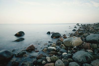 Rocks in sea against sky