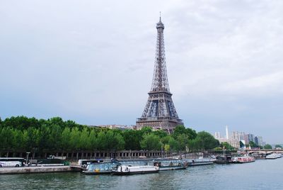 View of tower in city against cloudy sky