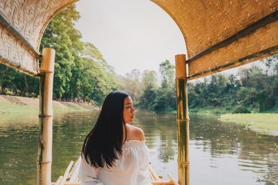 Woman looking away in houseboat over river