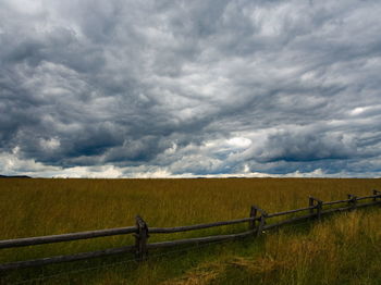 Scenic view of field against cloudy sky