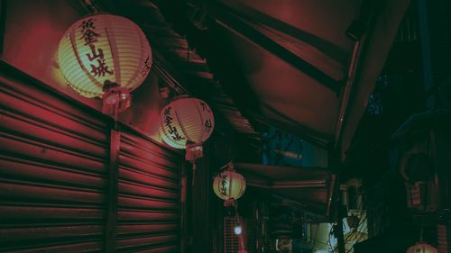 Low angle view of illuminated lanterns hanging at market stall