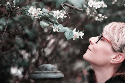 Portrait of woman with pink flowers against blurred background