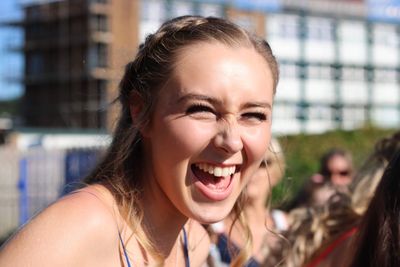 Close-up of cheerful teenage girl in city during sunny day