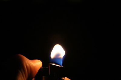 Close-up of lit candle in dark room