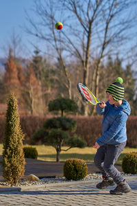 Man playing with umbrella against sky