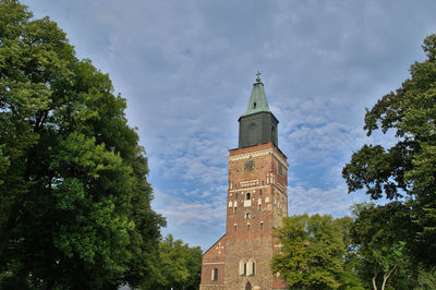 Low angle view of trees and building against sky