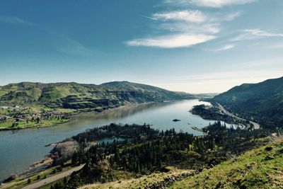 Scenic view of river and mountains against sky