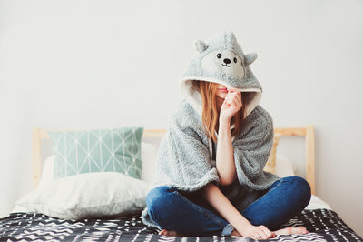 Full length of young woman sitting at home