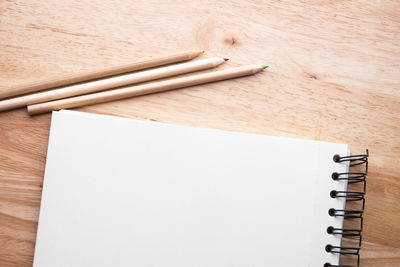 Note pad and pencils on wooden table