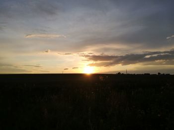 Scenic view of silhouette field against sky during sunset