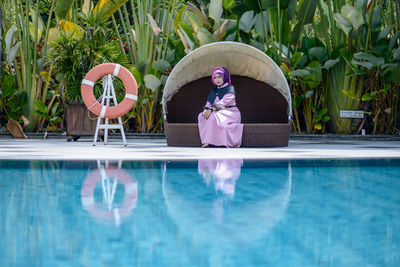 Woman standing by swimming pool