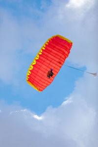 Low angle view of person paragliding against sky