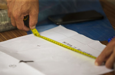 Close up of carpenter measuring plank