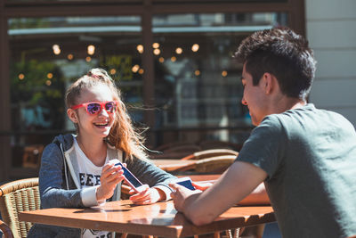 Portrait of happy woman sitting on table at restaurant