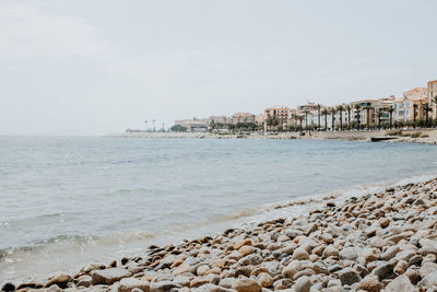 Scenic view of sea by buildings against sky