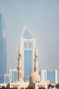 Tower amidst buildings against clear sky