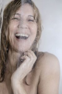 Portrait of woman in wet glass