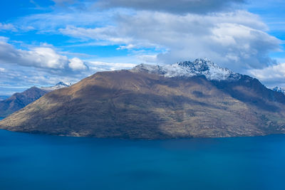 Scenic view of sea and mountains against blue sky