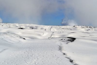 Scenic view of snow covered land against sky