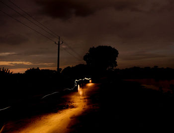 Silhouette of electricity pylon against sky during sunset