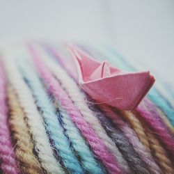 Close-up of paper boat on colorful wool