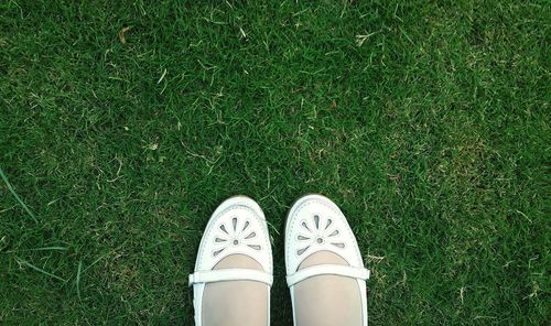 Low section of woman standing on grassy field