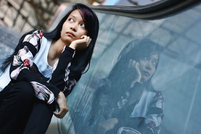 Portrait of a young woman sitting outdoors