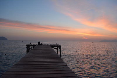 Pier over sea against sky during sunset