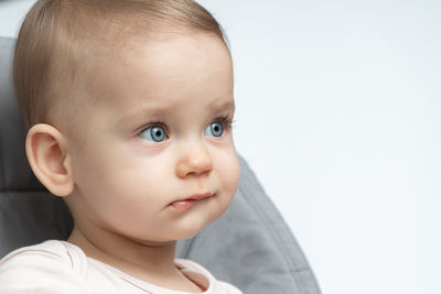 Close-up of cute baby boy against white background