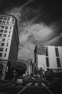 Traffic on city street by buildings against sky