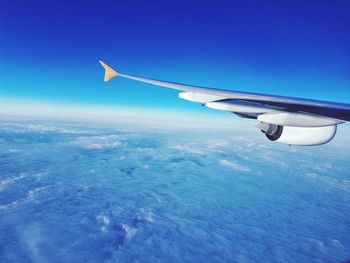 Close-up of airplane wing against blue sky