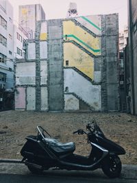 Damaged bicycle in city against buildings