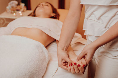 Low section of woman sitting on bed