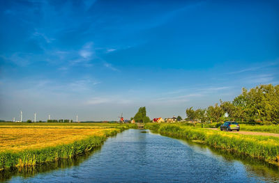 Scenic view of river against blue sky