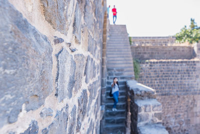 Low angle view of people on staircase against wall