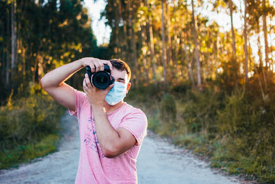Young man wearing mask and taking a photograph