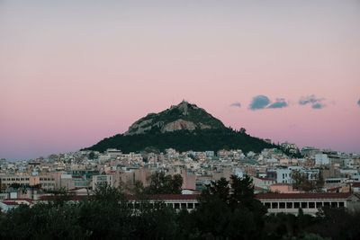 Buildings in city against sky at sunset