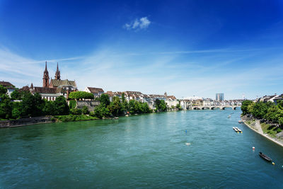 View of river in city against blue sky