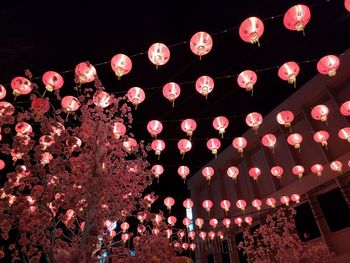 Low angle view of illuminated lanterns hanging at night