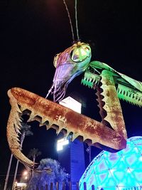 Low angle view of illuminated chain swing ride at night
