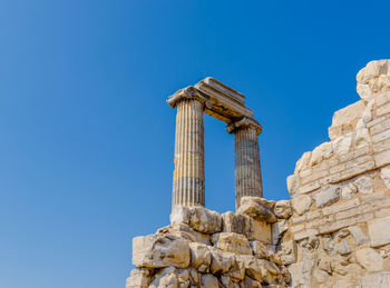 Low angle view of old ruin against blue sky