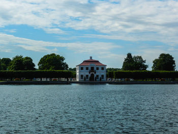 Scenic view of lake by building against sky